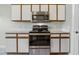 Close up of stainless steel oven and microwave combo with white and brown cabinets at 2711 Bayview Dr, Eustis, FL 32726