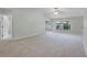 Bright and spacious living area featuring neutral carpeting, a ceiling fan, and sliding glass doors to the lanai at 2711 Bayview Dr, Eustis, FL 32726