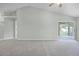 Spacious and neutral carpeted living room with high ceilings and large sliding glass doors providing access to outdoor living at 2711 Bayview Dr, Eustis, FL 32726