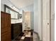 Bathroom with a wood vanity, decorative mirror, and a shower with patterned tile at 2850 Aragon Ter, Lake Mary, FL 32746