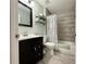 Updated bathroom with a dark vanity, decorative mirror, and tiled shower with updated fixtures at 2850 Aragon Ter, Lake Mary, FL 32746