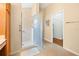 Bathroom featuring tile shower with glass door, and view to walk in closet and exterior hall at 3008 Bridgefield Ct, The Villages, FL 32162