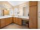 Spacious bathroom with dual sinks, granite counters, and wooden cabinetry with a vanity area and tile flooring at 3008 Bridgefield Ct, The Villages, FL 32162