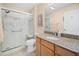 Bright bathroom featuring a glass enclosed shower with bench and a granite-topped vanity with storage at 3008 Bridgefield Ct, The Villages, FL 32162