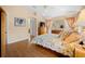 Bright bedroom featuring wood floors, vaulted ceilings, neutral walls, and furnishings with a large floral bedspread at 3008 Bridgefield Ct, The Villages, FL 32162