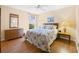 Bedroom with wood floors, full bed with matching end tables, and dresser in the corner at 3008 Bridgefield Ct, The Villages, FL 32162