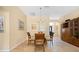Warm dining area with a glass table and four chairs, with art and natural light at 3008 Bridgefield Ct, The Villages, FL 32162
