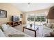 Bright living room featuring vaulted ceilings, tile floors, and sliding glass doors to the lanai at 3008 Bridgefield Ct, The Villages, FL 32162