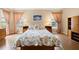 Spacious main bedroom featuring wood floors, bedside tables, and large windows at 3008 Bridgefield Ct, The Villages, FL 32162