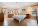 Bright main bedroom with wood floors, bedside tables, and a ceiling fan at 3008 Bridgefield Ct, The Villages, FL 32162