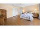 Bedroom with wood floors, ceiling fan, dual closets, lamps and dressers on either side of bed at 3008 Bridgefield Ct, The Villages, FL 32162