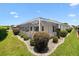 Backyard features a covered patio, well manicured shrubbery, and plenty of green space at 3008 Bridgefield Ct, The Villages, FL 32162