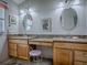 Bathroom with double vanity, granite countertop, decorative mirrors, and stool at 3112 Burbank Ln, The Villages, FL 32162