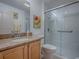 Well-lit bathroom featuring a single vanity, framed art, and a glass-enclosed shower at 3112 Burbank Ln, The Villages, FL 32162