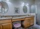 Bathroom features granite counters, dual sinks, decorative mirrors and tiled glass shower at 3112 Burbank Ln, The Villages, FL 32162