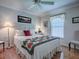 Cozy bedroom featuring a decorative quilt, wood floors, and a ceiling fan at 3112 Burbank Ln, The Villages, FL 32162