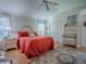 Cozy bedroom with a plush red bedspread and an elegant, neutral-toned area rug at 3112 Burbank Ln, The Villages, FL 32162