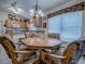 Dining area with floral upholstered chairs, views of kitchen, and natural light at 3112 Burbank Ln, The Villages, FL 32162