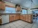 Functional kitchen featuring wood cabinets, white appliances, granite countertops, and tile flooring at 3112 Burbank Ln, The Villages, FL 32162