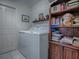Well-organized laundry room with appliances and built-in shelving and decorations at 3112 Burbank Ln, The Villages, FL 32162