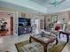 Inviting living room with fireplace, plush seating, neutral tones, and French doors at 3112 Burbank Ln, The Villages, FL 32162