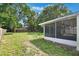 Expansive backyard featuring a lush lawn and a screened-in patio, perfect for outdoor enjoyment at 315 W 11Th Ave, Mount Dora, FL 32757