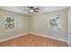Cozy bedroom with wood-look flooring, neutral walls, two windows, and natural light at 315 W 11Th Ave, Mount Dora, FL 32757