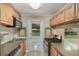 Kitchen featuring stainless steel appliances, wood cabinetry, granite counters, and access to the backyard at 315 W 11Th Ave, Mount Dora, FL 32757