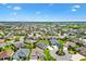 An aerial showcases a manicured neighborhood with beautiful homes and green spaces bordering tranquil lakes and golf course at 3405 Nursery Pl, The Villages, FL 32163