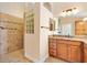 Bathroom with a glass block window and a tiled shower with a granite topped vanity at 3405 Nursery Pl, The Villages, FL 32163