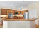Well-lit kitchen features granite countertops, stainless steel appliances, and wooden cabinetry at 3405 Nursery Pl, The Villages, FL 32163
