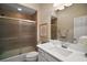Updated bathroom featuring tile shower with glass doors, white vanity and toilet at 3411 Eisenhower Way, The Villages, FL 32163