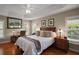 Warm bedroom featuring a tray ceiling, hardwood floors, and windows at 3411 Eisenhower Way, The Villages, FL 32163
