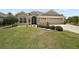 Charming single-story home featuring a well-manicured lawn, mature landscaping, and a two-car garage at 3411 Eisenhower Way, The Villages, FL 32163