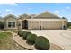 Inviting home exterior showcasing a manicured lawn, decorative driveway, and a convenient two-car garage at 3411 Eisenhower Way, The Villages, FL 32163