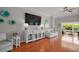 Living room features a large entertainment center, neutral furniture, and access to a bright sunroom at 3411 Eisenhower Way, The Villages, FL 32163