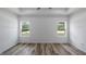 Bright bedroom featuring wood-look floors, two windows, and neutral walls at 40685 E Ninth Ave, Umatilla, FL 32784