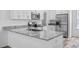 Bright kitchen with stainless steel appliances, white cabinets, and granite countertops at 40685 E Ninth Ave, Umatilla, FL 32784