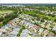 Expansive aerial view of a vibrant residential community surrounded by lush greenery and a tranquil lake at 412 Hildalgo Dr, The Villages, FL 32159