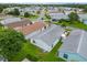 Aerial view of a backyard with well-kept lawn, shaded patio, and a glimpse of the surrounding neighborhood at 412 Hildalgo Dr, The Villages, FL 32159