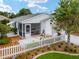 Charming single-story home featuring a cozy screened porch and a well-manicured front yard with a classic white picket fence at 412 Hildalgo Dr, The Villages, FL 32159
