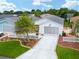 Inviting home showcasing a well-kept lawn, charming picket fence, and a convenient driveway at 412 Hildalgo Dr, The Villages, FL 32159