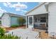 Inviting screened front porch with comfortable seating, decorative elements, and a view of the landscaped yard at 412 Hildalgo Dr, The Villages, FL 32159