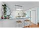 Bright kitchen features an island bar with seating, white appliances, and pendant lighting at 412 Hildalgo Dr, The Villages, FL 32159