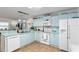Bright kitchen features white appliances, light blue cabinetry, and tile floors at 412 Hildalgo Dr, The Villages, FL 32159