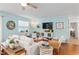 Open-concept living room area, featuring hardwood floors, comfortable seating, and natural light at 412 Hildalgo Dr, The Villages, FL 32159