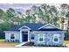 Charming single-story home featuring stone accents and a well-manicured lawn with a backdrop of mature trees at 41346 Persimmon St, Eustis, FL 32736