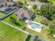 Aerial view of a private backyard featuring an in-ground pool, patio area, lush lawn, and white vinyl fencing for privacy at 4730 Se 31St St, Ocala, FL 34480