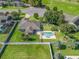 Aerial view of a beautifully landscaped backyard featuring a pristine in-ground pool, patio, and lush greenery with privacy fence at 4730 Se 31St St, Ocala, FL 34480