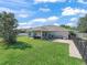 Wide angle view of the backyard featuring a patio, green grass, and white fencing at 4730 Se 31St St, Ocala, FL 34480